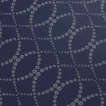 Detail of a wallpaper in a playful floral lattice print in white and tan on a navy blue field.