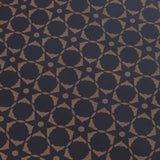 Wallpaper detail in a floral lattice print in  kraft brown on a navy field