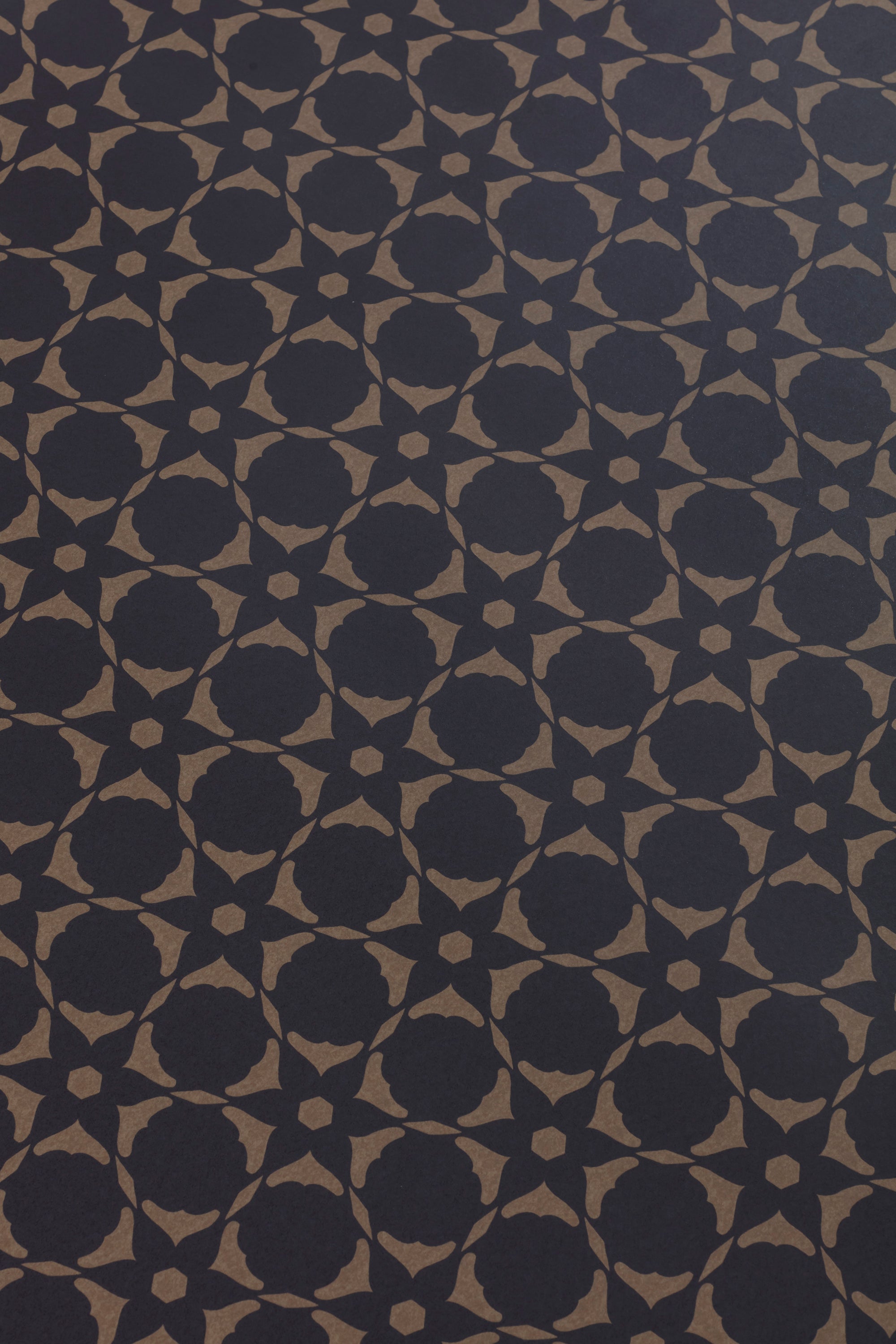 Wallpaper detail in a floral lattice print in  kraft brown on a navy field