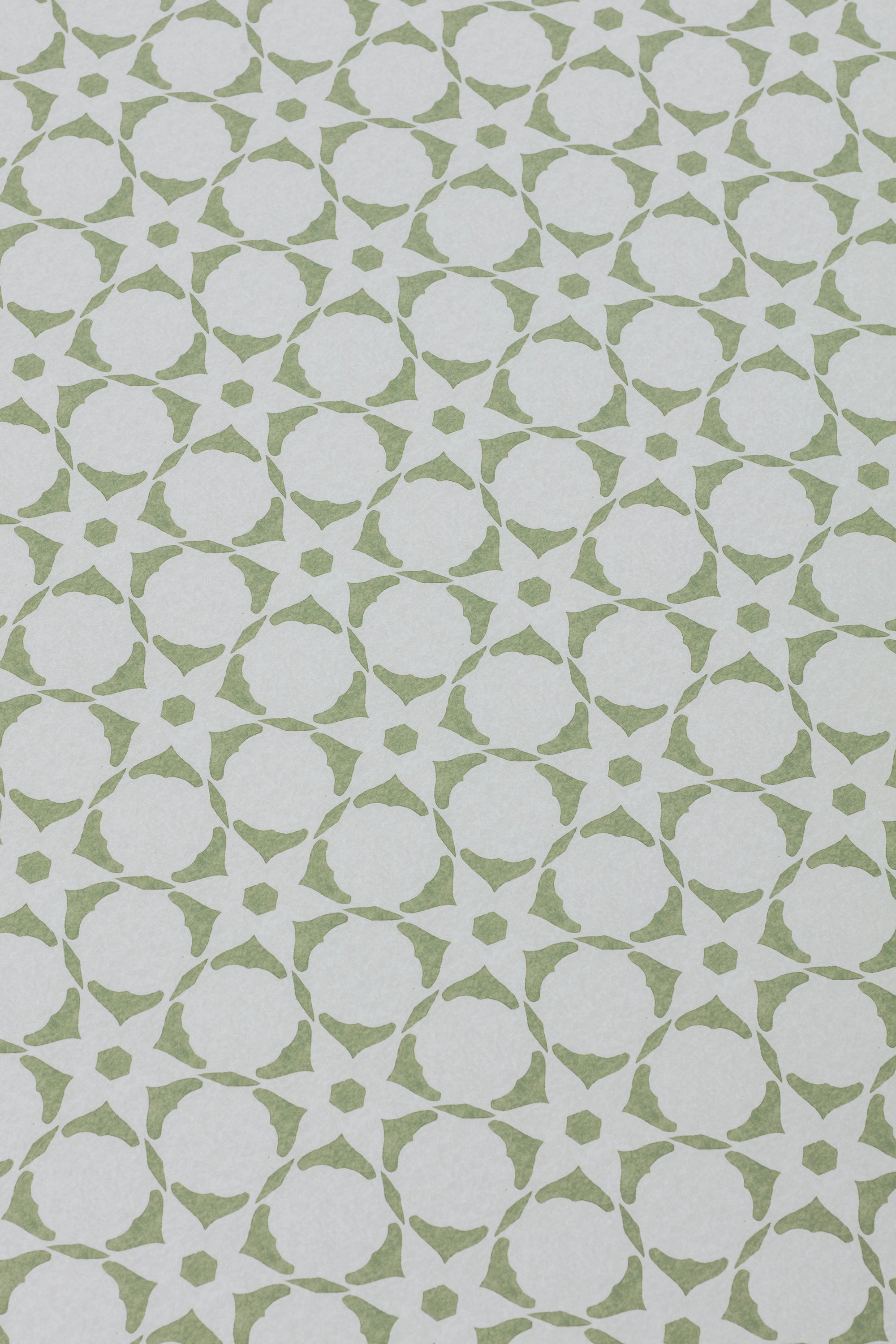 Wallpaper detail in a floral lattice print in  cream on a jade green field.