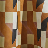 Draped wallpaper yardage in geometric grid print in shades of rust, yellow and gray on a cream field.