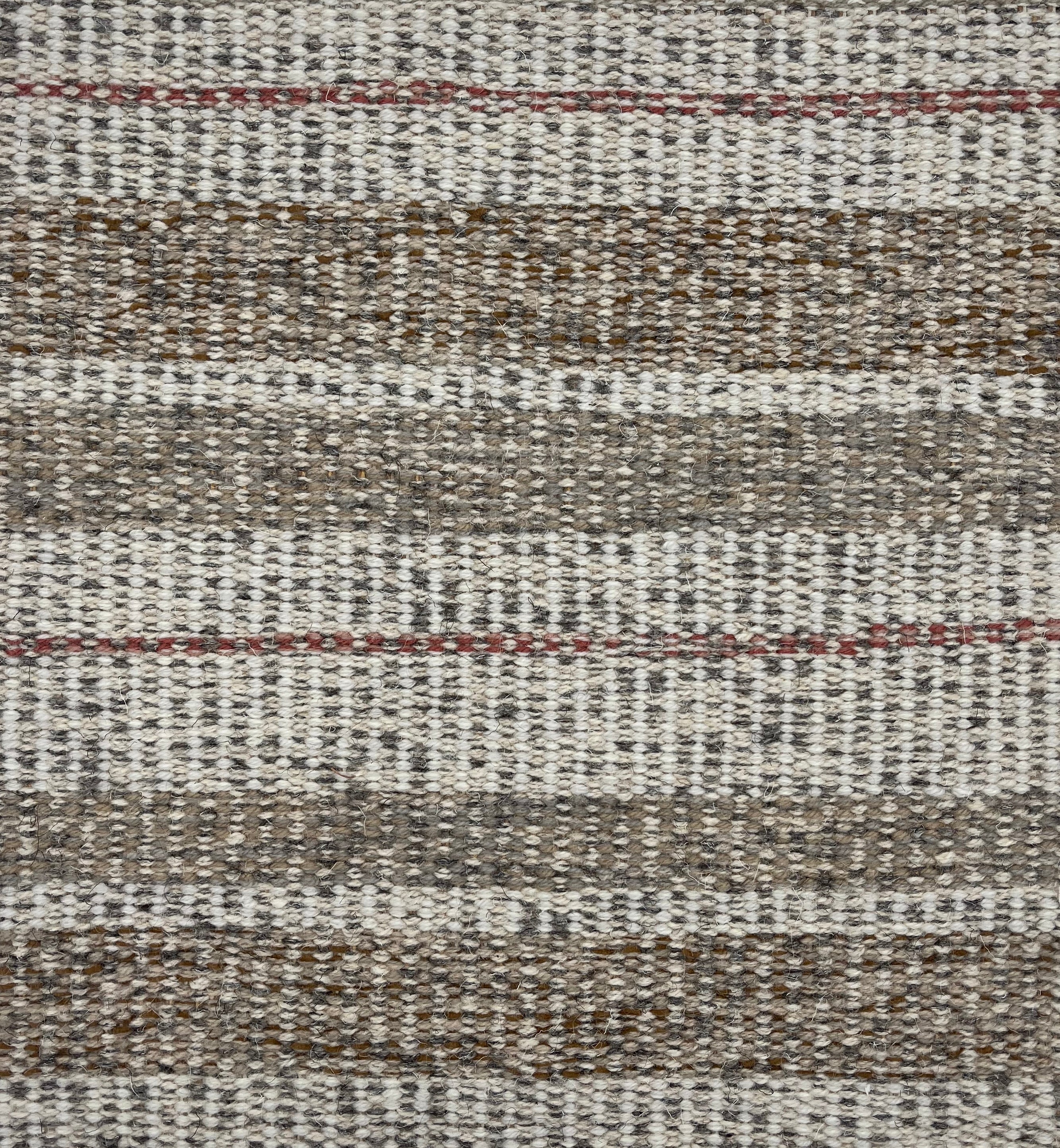 Handwoven carpet in a mixed width stripe in white, brown, charcoal and rust. 