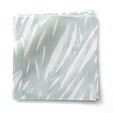 Stacked fabric swatches in an abstract leaf pattern in white on a pale aqua watercolor field.