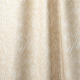 Draped linen in  an abstract leaf pattern in white on a pale yellow watercolor field.