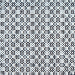 Flatweave rug in a small scale decorative lattice design in cream on a dark grey field. 