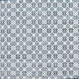 Flatweave rug in a small scale decorative lattice design in cream on a chambray blue field.