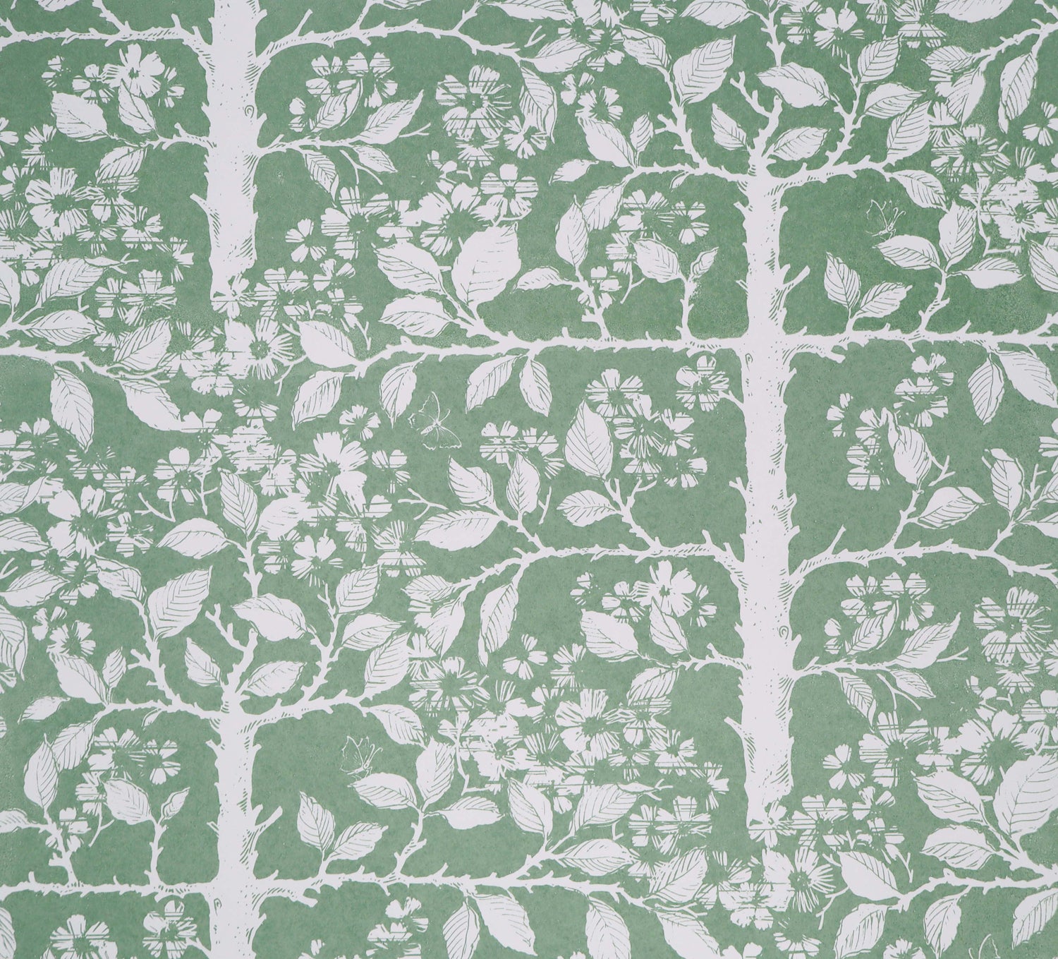 White tree and leaf design on a green field. 