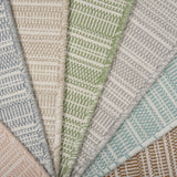 Stack of broadloom carpets in a textural stripe in a range of colors. 