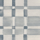 Detail of wallpaper in a large-scale checked pattern in shades of steel blue and pale grey.