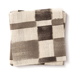Stacked swatches of fabric in a large-scale checked pattern in shades of charcoal grey and cream.
