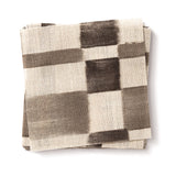 Stacked swatches of fabric in a large-scale checked pattern in shades of charcoal grey and cream.