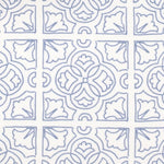 Detail of fabric in a damask lattice print in blue on a white field.