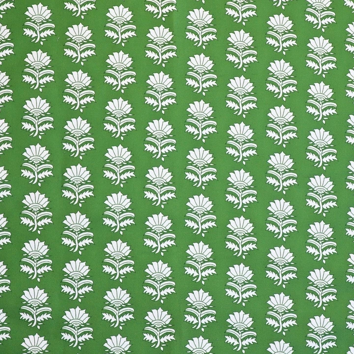 Detail of fabric in a repeating thistle print in white and green on a green field.
