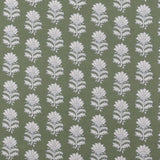 Detail of fabric in a repeating thistle print in white and blue on a green field.