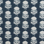 Detail of fabric in a repeating thistle print in white and blue on a navy field.