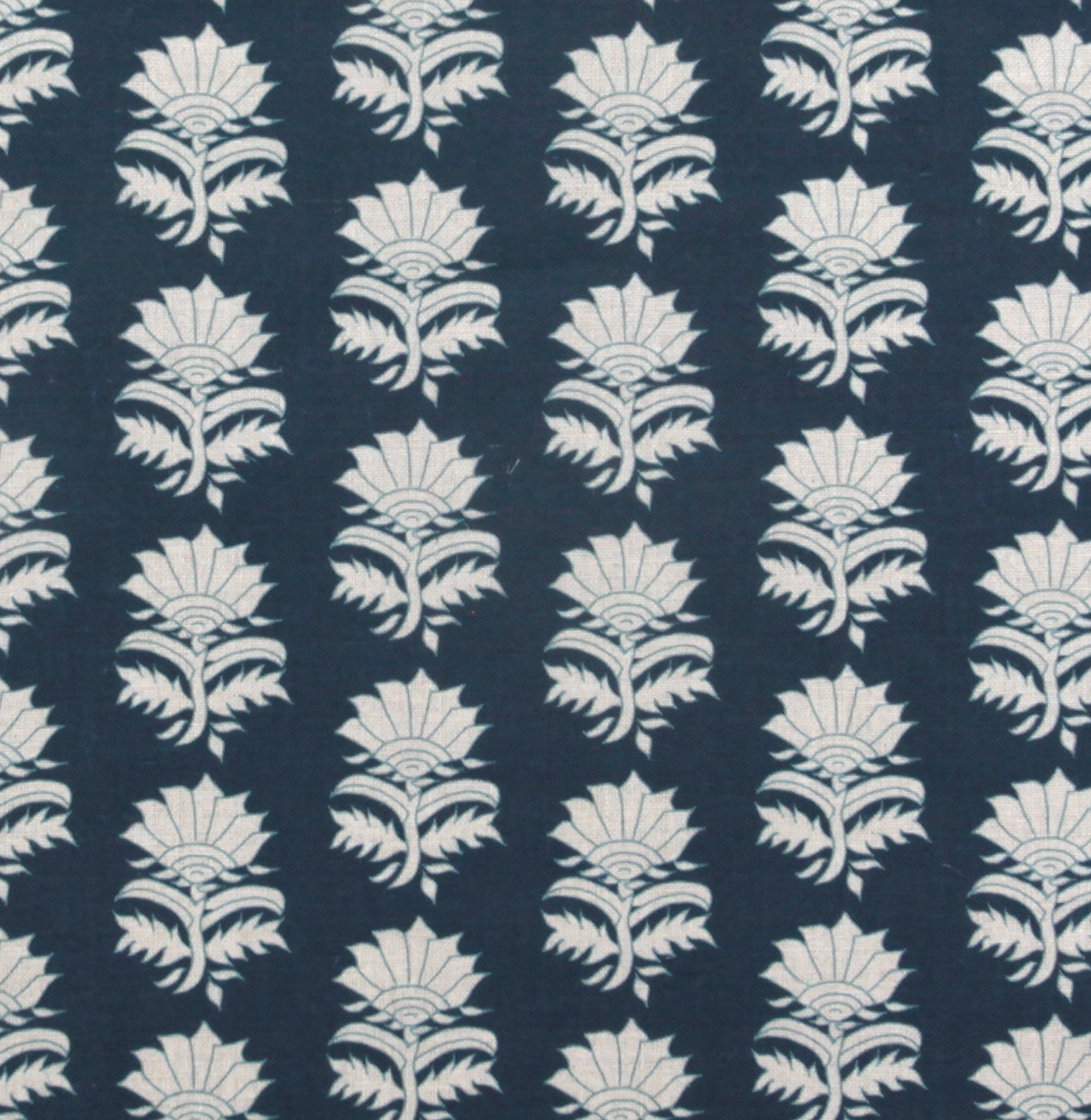 Detail of fabric in a repeating thistle print in white and blue on a navy field.