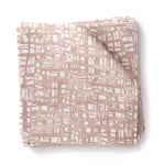 Stacked swatches of fabric in a textural wicker pattern in blush pink on a white field. 