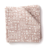 Stacked swatches of fabric in a textural wicker pattern in blush pink on a white field. 