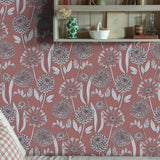 Cozy reading nook with a decorative wooden shelf against a pink floral wallpaper. 