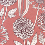 Detail of fabric in a large-scale floral print in purple and white on a light pink field.