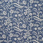 A close-up of a repeating floral and vine pattern in muted denim blue and off-white.