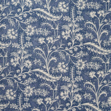 A close-up of a repeating floral and vine pattern in muted denim blue and off-white.