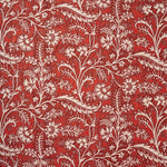 A close-up of a repeating floral and vine pattern in bright red and off-white.