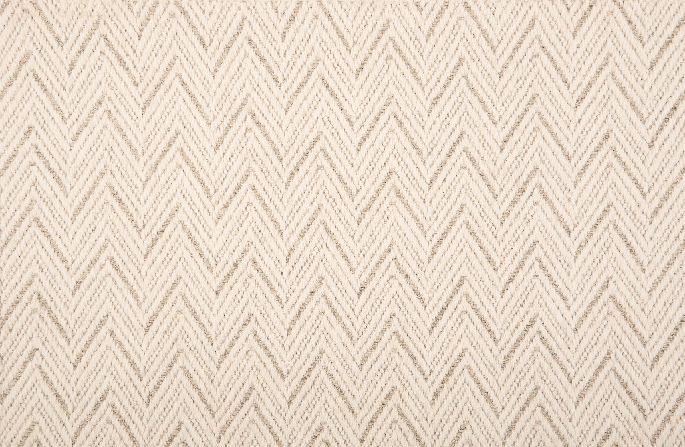 Broadloom carpet in a herringbone pattern in cream with taupe accents.
