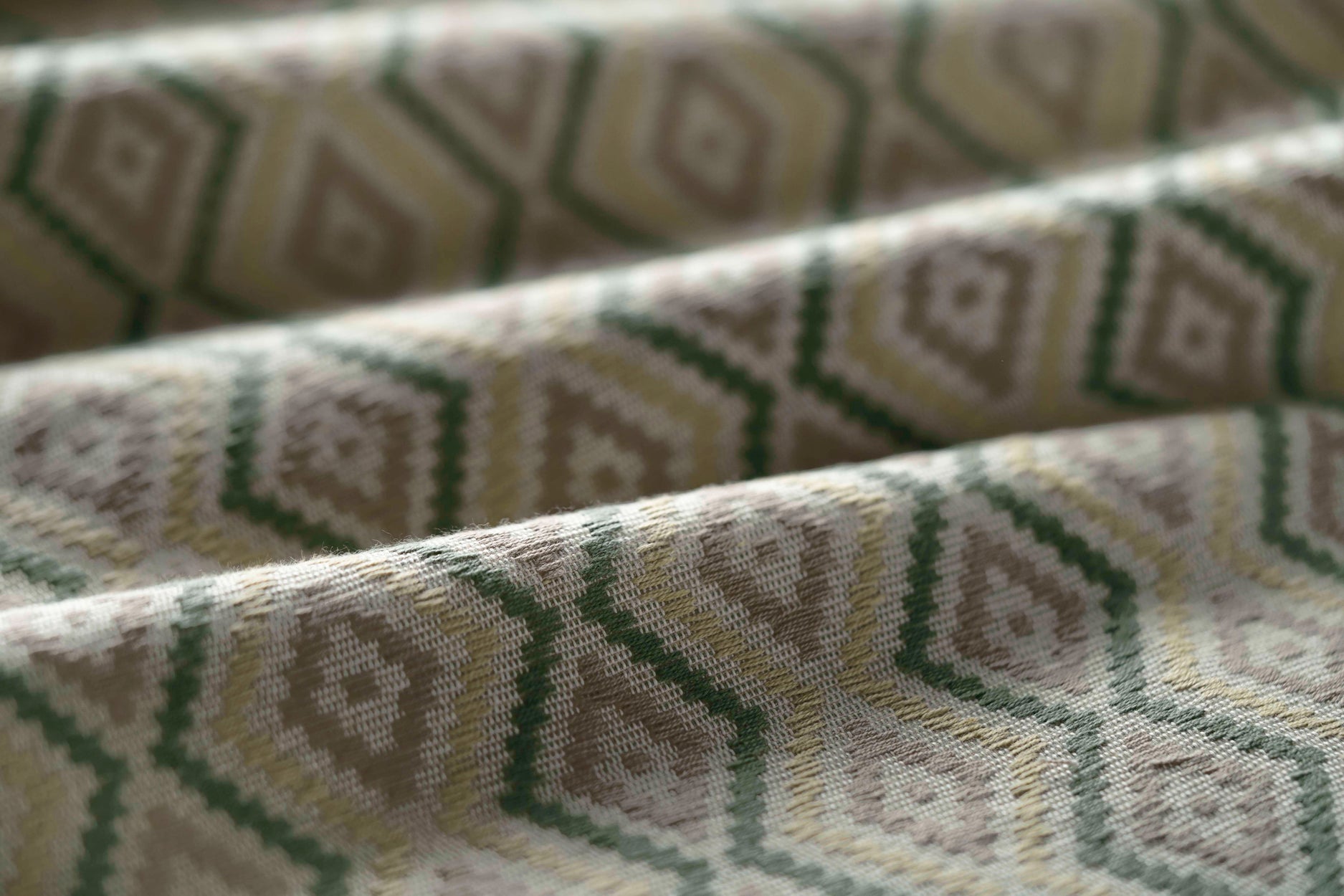 Close-up of textured fabric with geometric pattern in shades of green