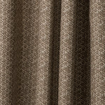 Draped printed fabric in a detailed geometric pattern in white on a dark brown field.