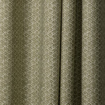 Draped printed fabric in a detailed geometric pattern in white on an olive field.