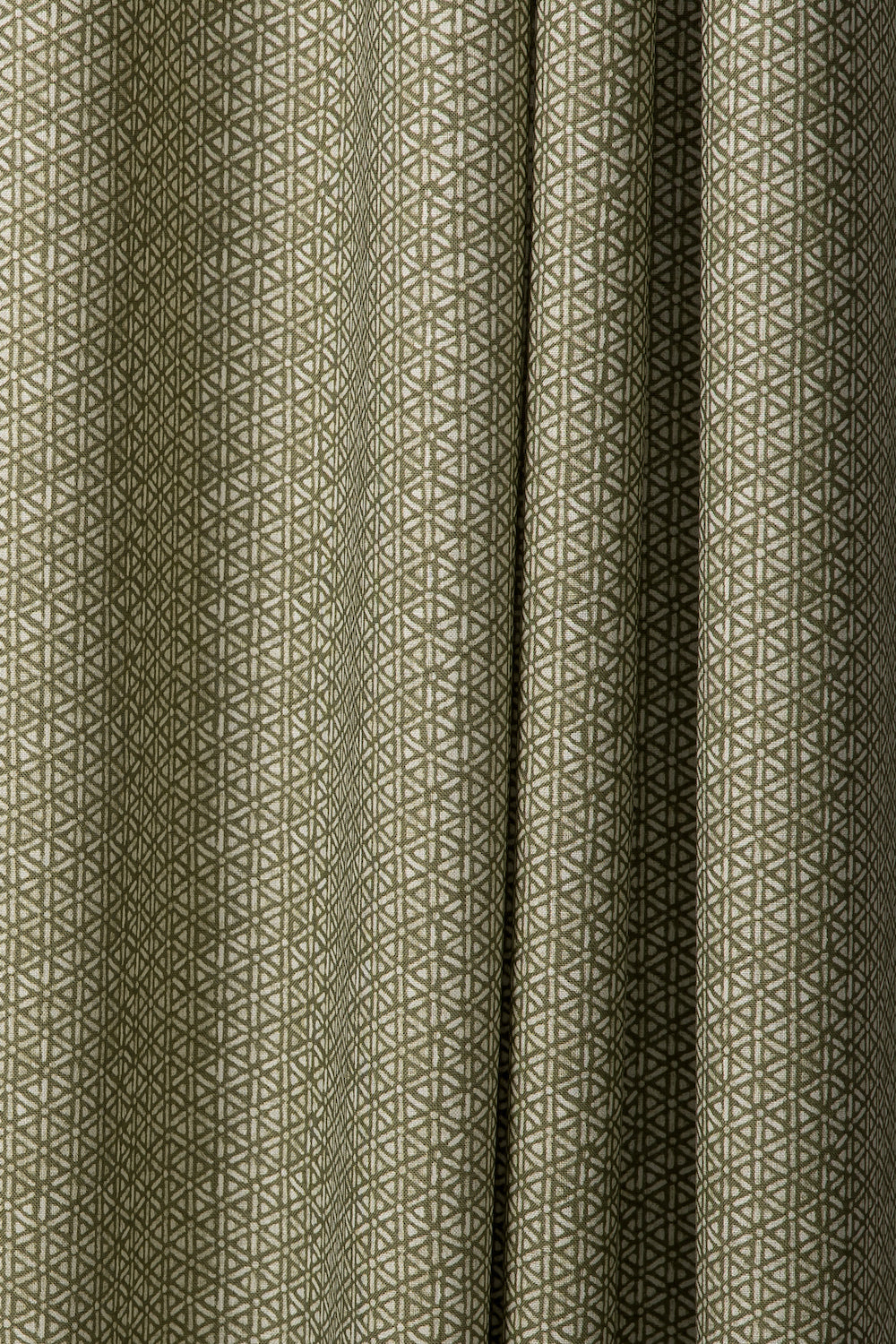 Draped printed fabric in a detailed geometric pattern in white on an olive field.