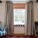 Chabby-chic living room with a large window and a wall papered in a playful cartoon "Pow" print in pink and cream.