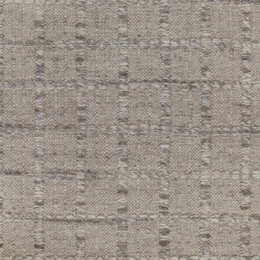 Broadloom carpet with raised gridded plaid in shades of grey and cream on a pale grey field.