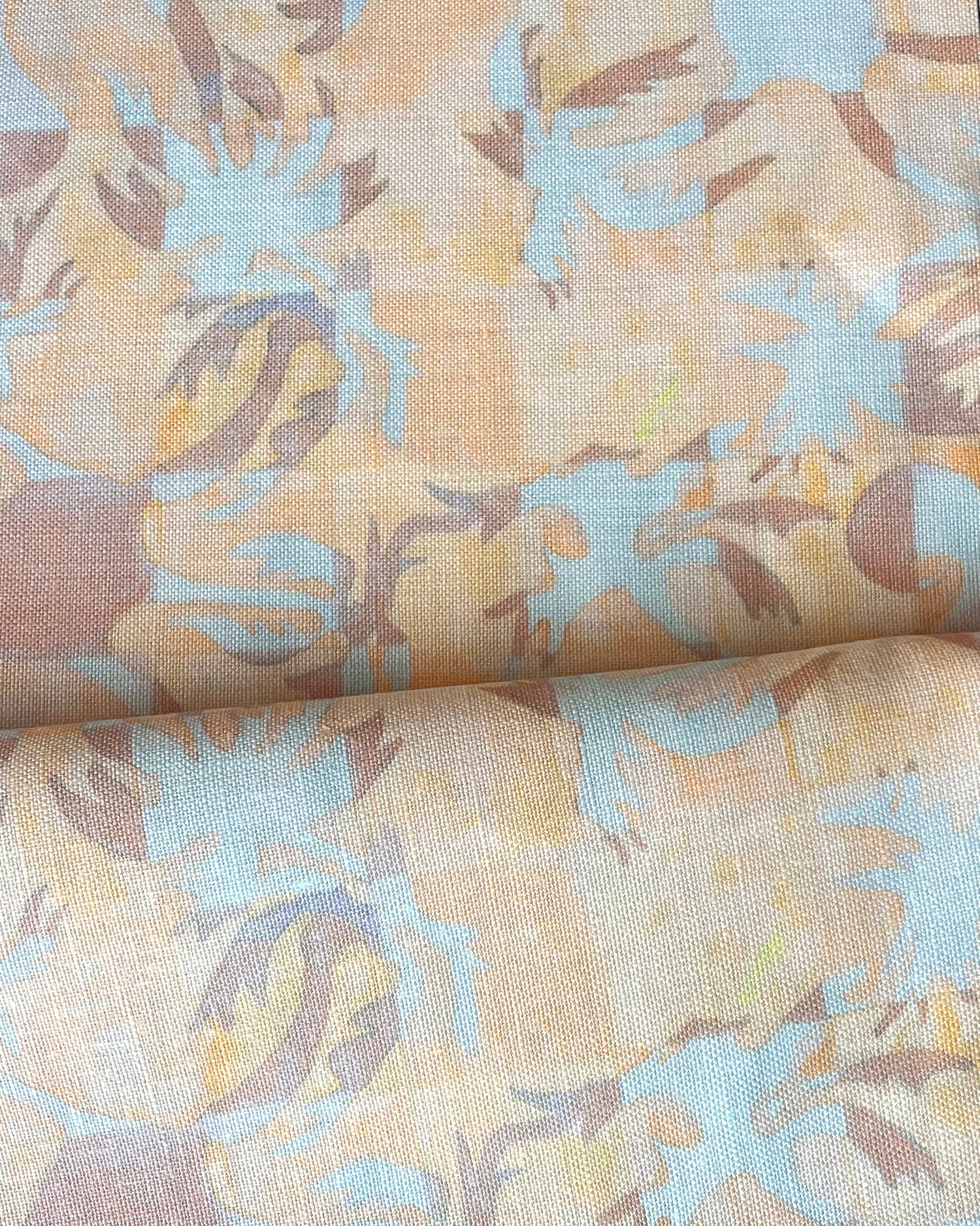 Draped fabric in painterly tropical checkerboard design in yellow, tan and blue. 