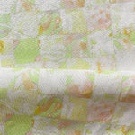 Draped fabric in painterly tropical checkerboard design in lime green, yellow and orange. 
