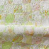 Draped fabric in painterly tropical checkerboard design in lime green, yellow and orange. 