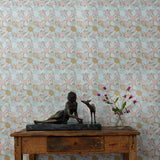 Wooden table with decorative items against a blue and ink tropical check patterned wallpaper.