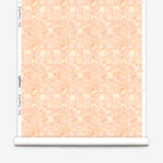 Roll of wallpaper in painterly tropical checkerboard design in pinky orange and yellow. 