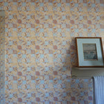 Tropical Check patterned wallpaper with a framed picture and towel on a shelf.