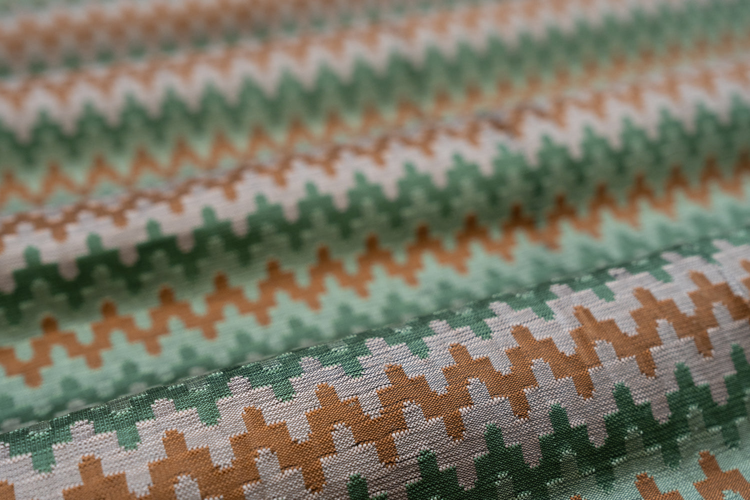 Close-up of fabric with green, pink and orange striped zig pattern