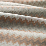 Close up of folded handwoven silk fabric with zigzag stripes in neutral colors. 