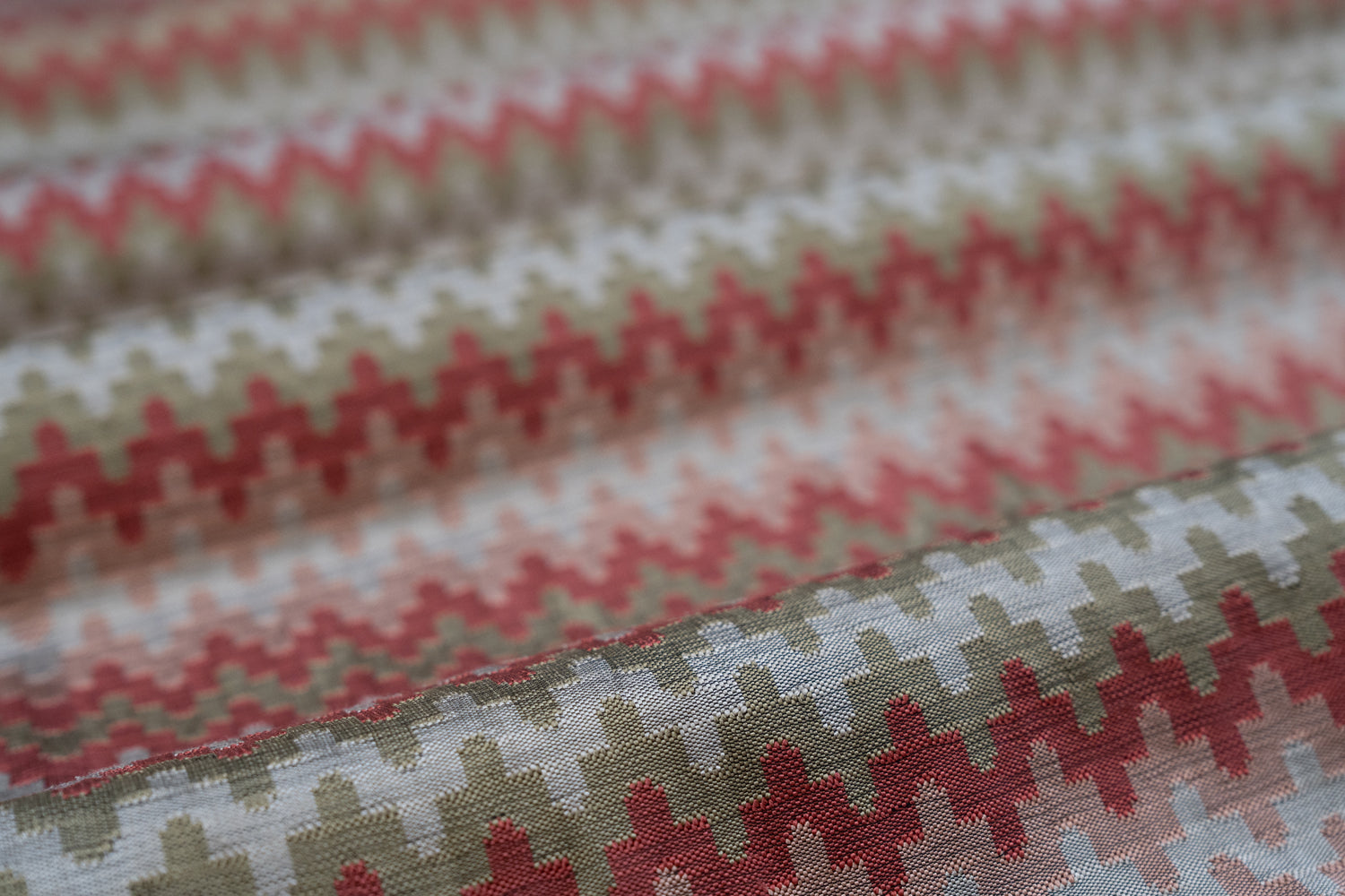 Close-up of fabric with a red and beige geometric pattern