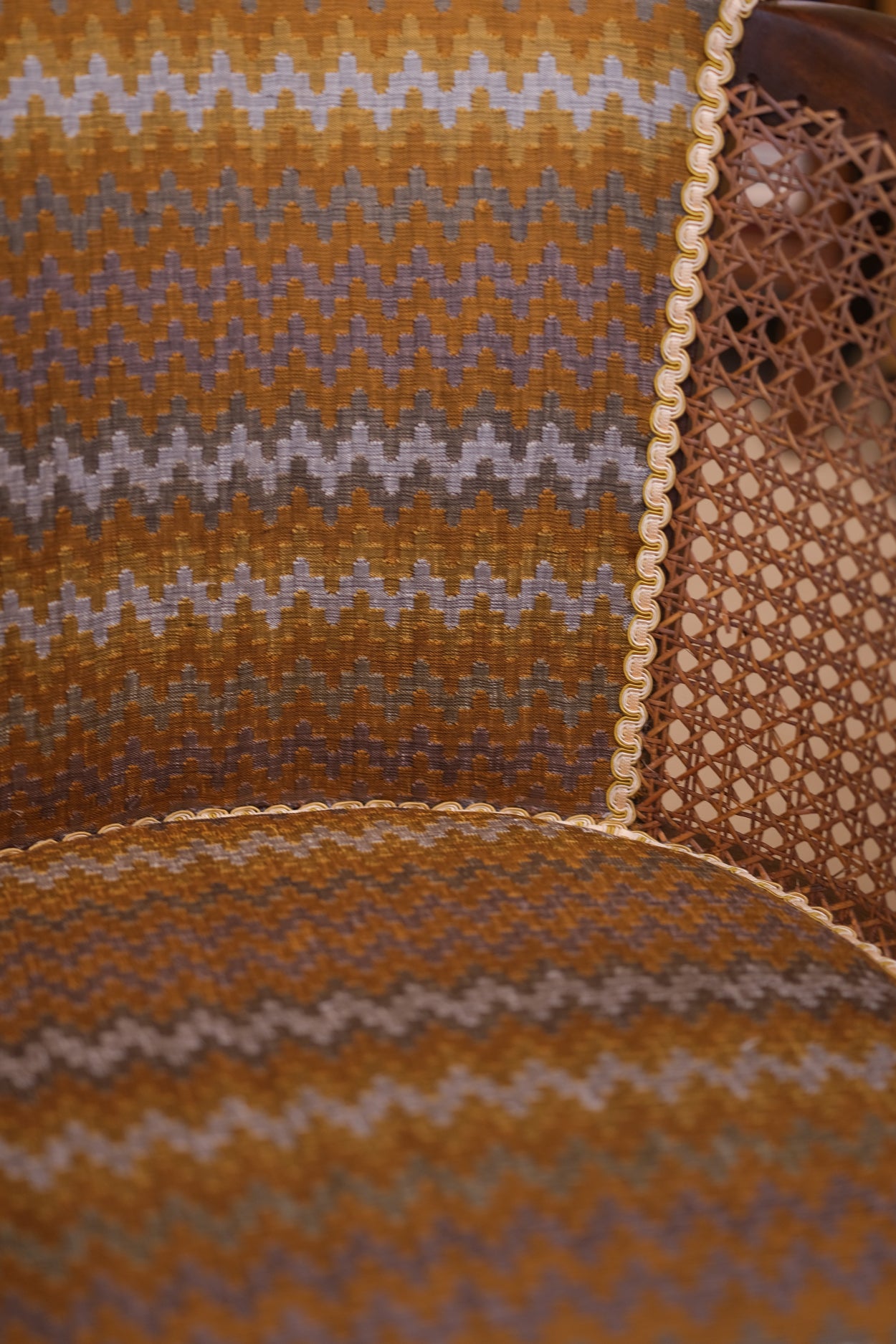 Textured fabric with wavy pattern in brown, beige, and purple on a brown background.