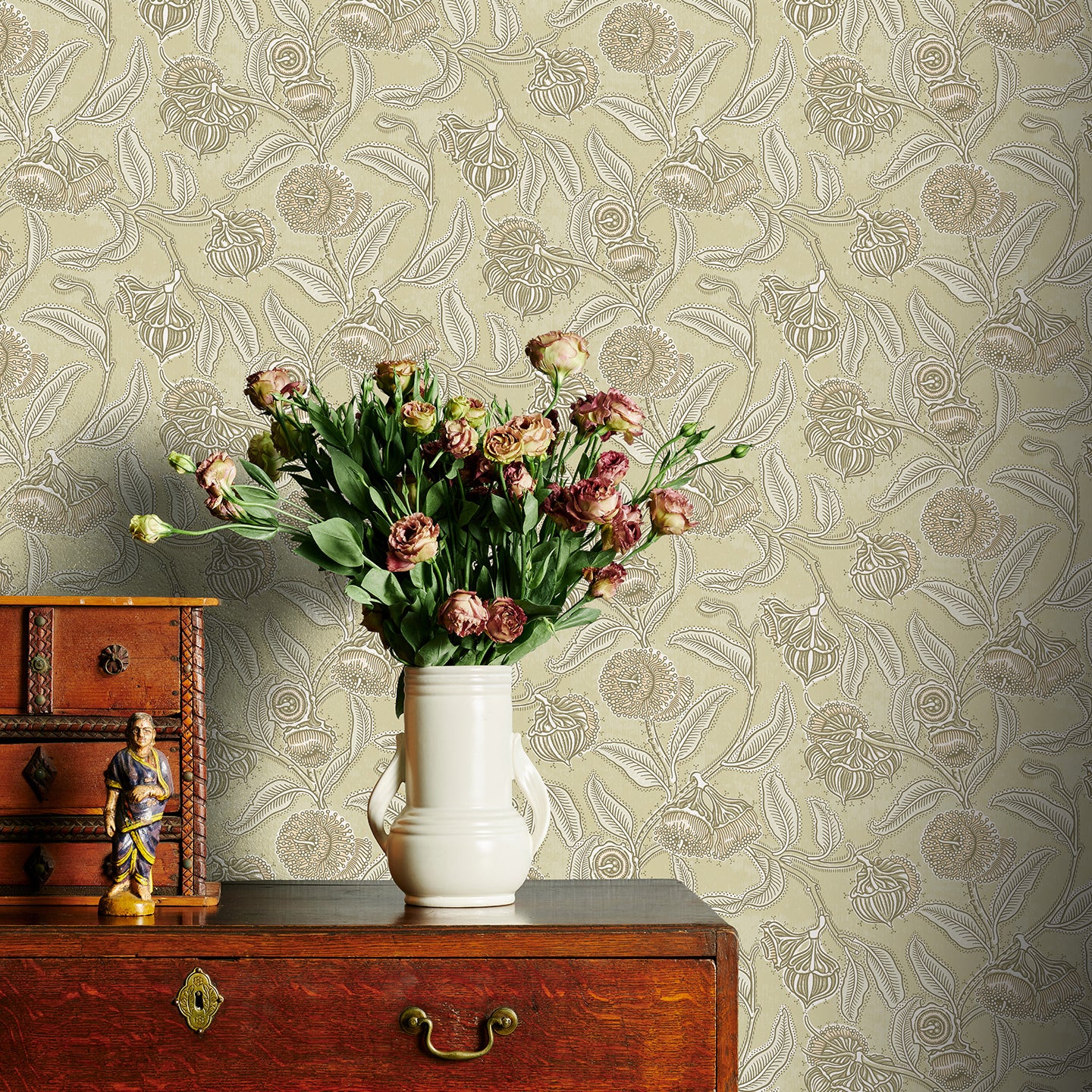 Decorative wallpaper with floral pattern, wooden dresser, and vase with flowers.