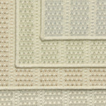 Stack of four broadloom carpet samples with textured stripe design in a palette of cream and pastel hues.