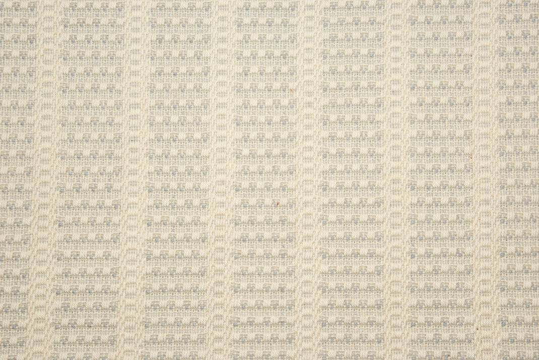 Broadloom carpet with textured stripe design in cream with light blue accents. 