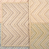Stack of broadloom carpets with zig zag pattern in various colors. 