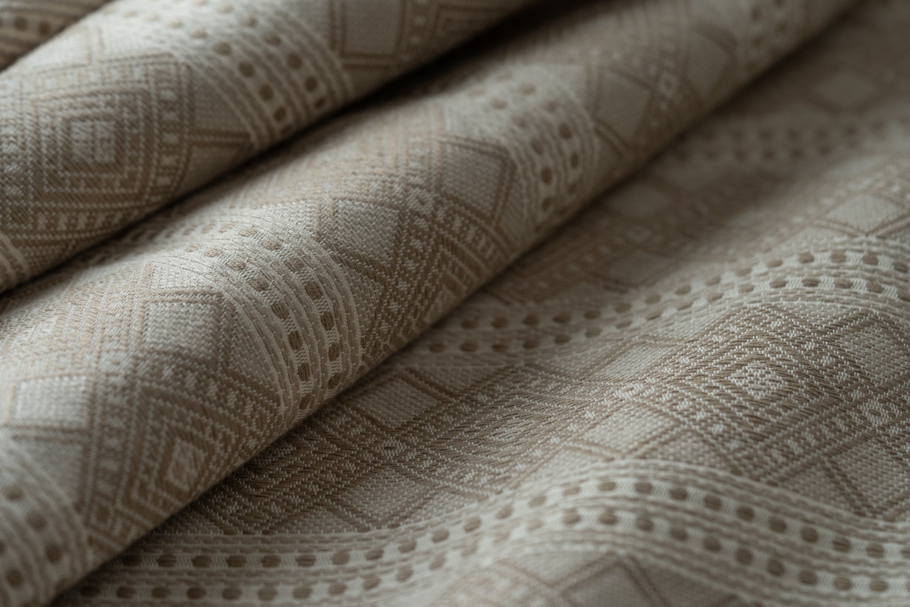 Close-up of textured beige fabric with geometric pattern