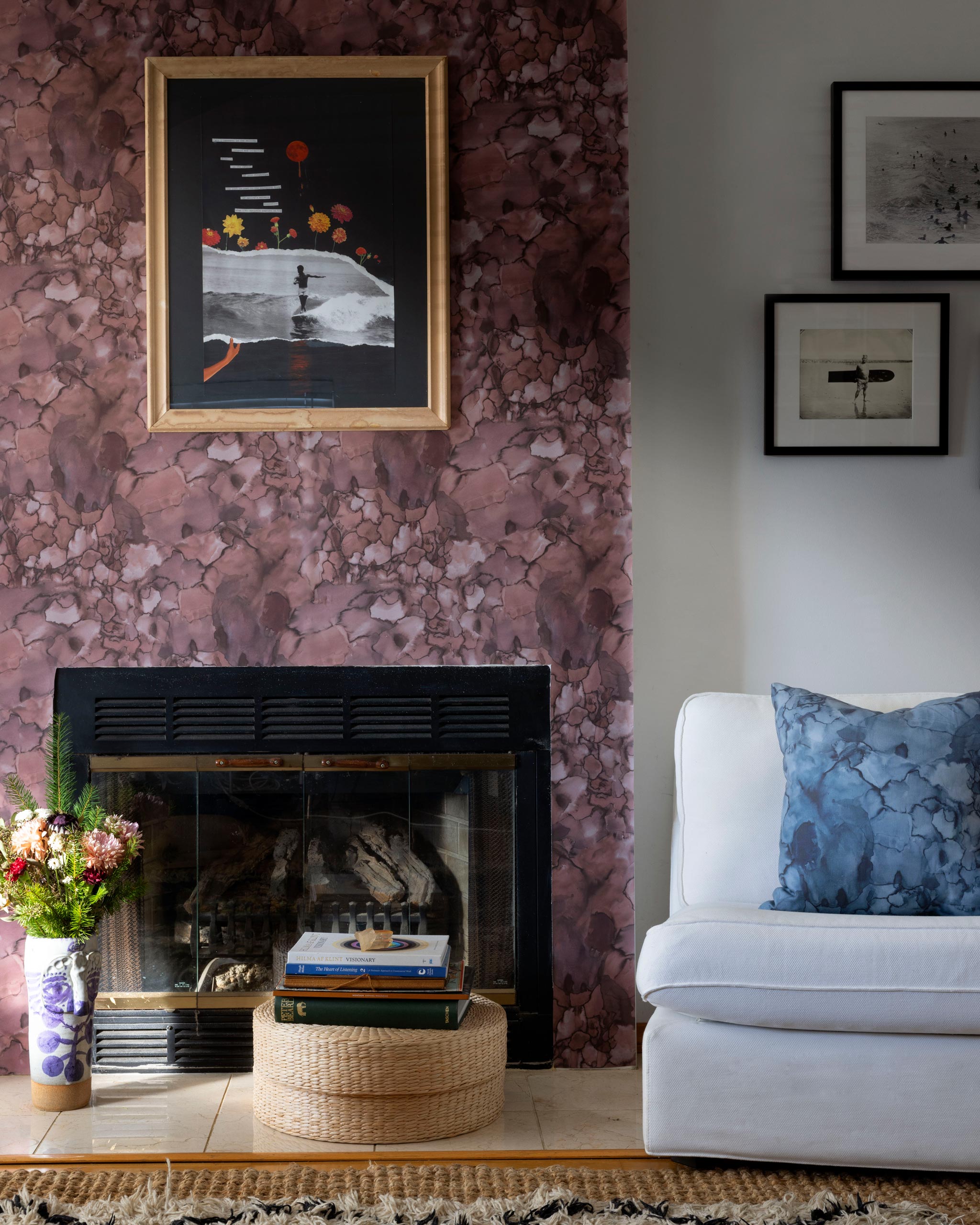 A maximalist living room tableau with a statement wall papered in a watercolor textural print in red, gray and black.
